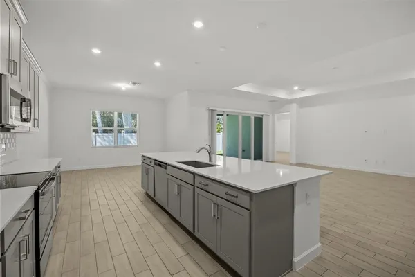a kitchen with a sink and wooden floor
