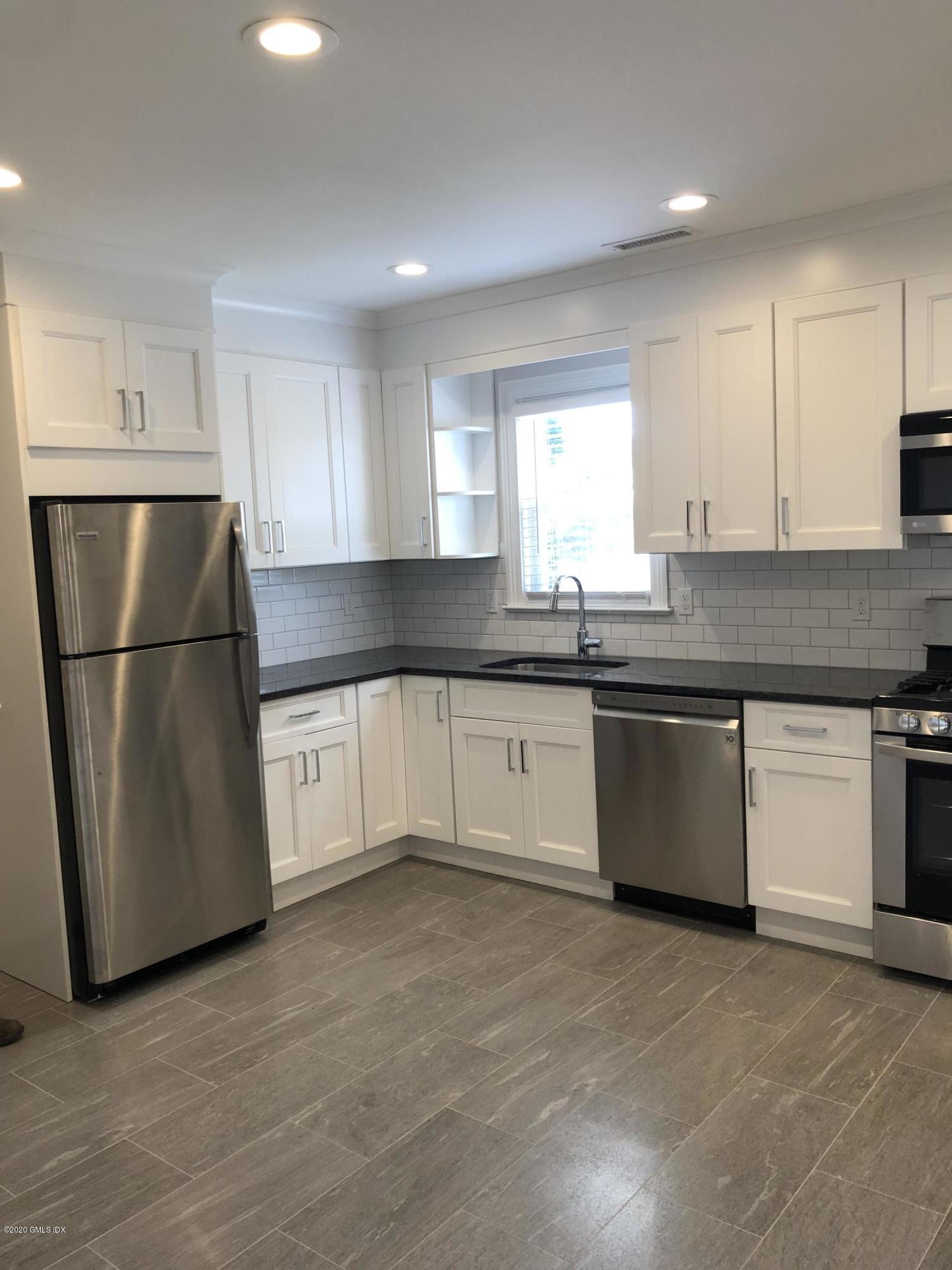 a kitchen with granite countertop white cabinets and white appliances