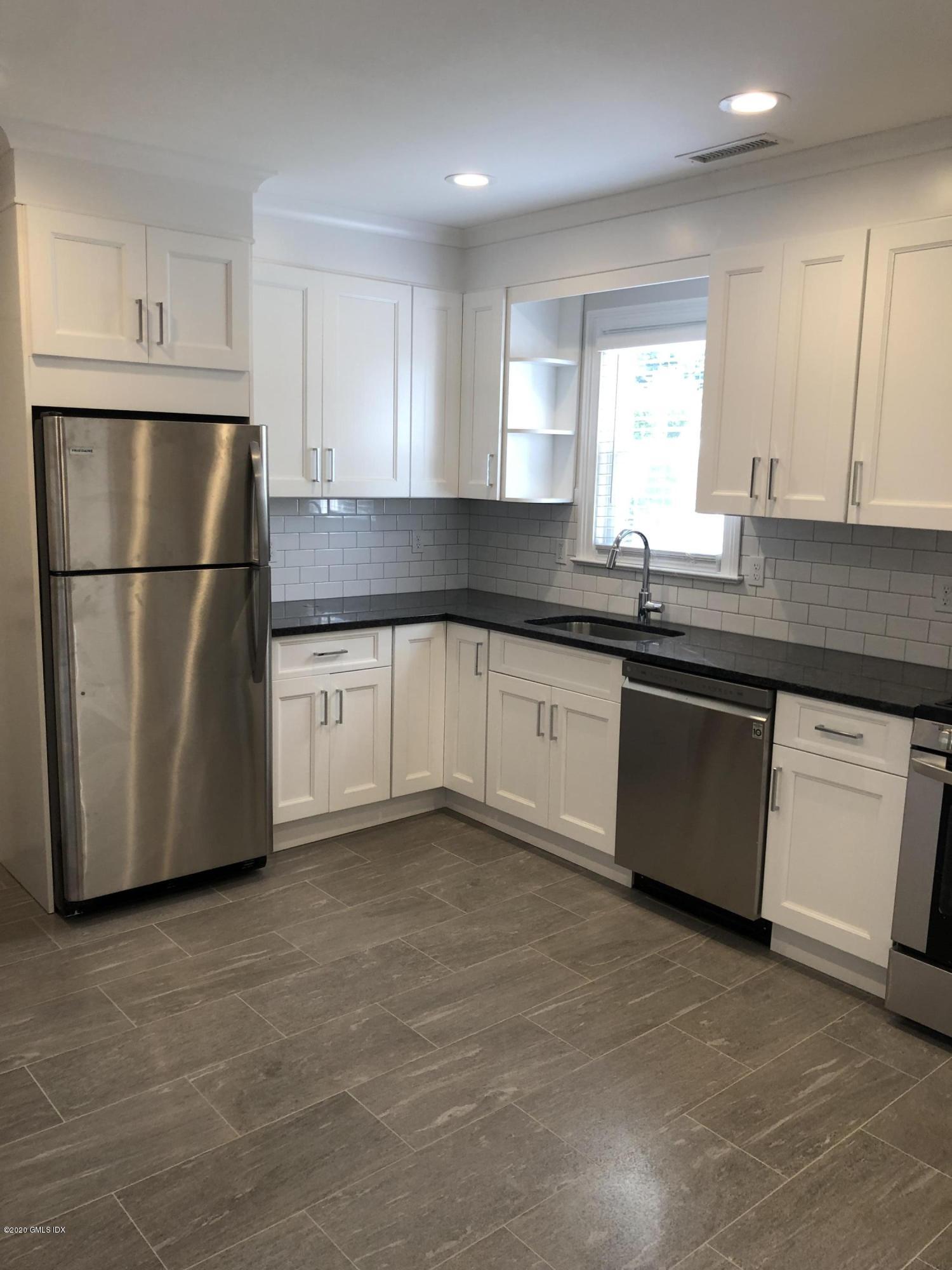30 Harold Avenue, Unit 2 Greenwich, CT 06830 - Photo 3 of 11 a kitchen with a sink a stove a refrigerator and white cabinets