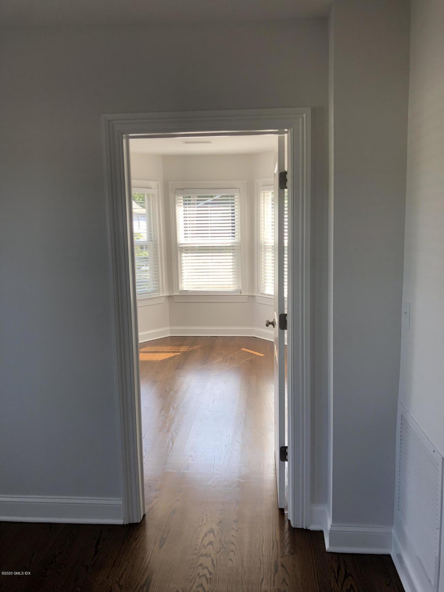30 Harold Avenue, Unit 2 Greenwich, CT 06830 - Photo 7 of 11 an empty room with wooden floor and windows