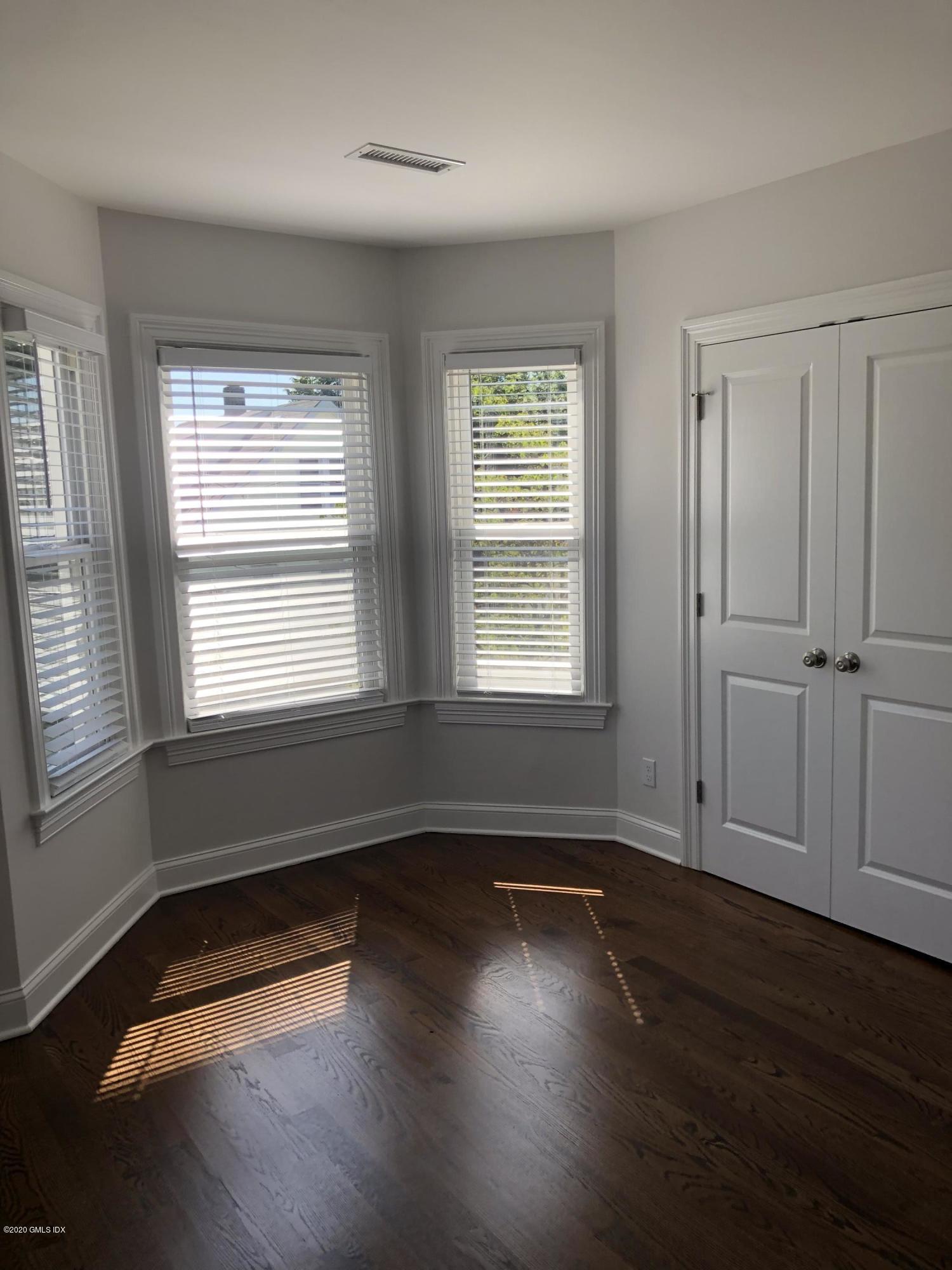 30 Harold Avenue, Unit 2 Greenwich, CT 06830 - Photo 8 of 11 an empty room with wooden floor and windows