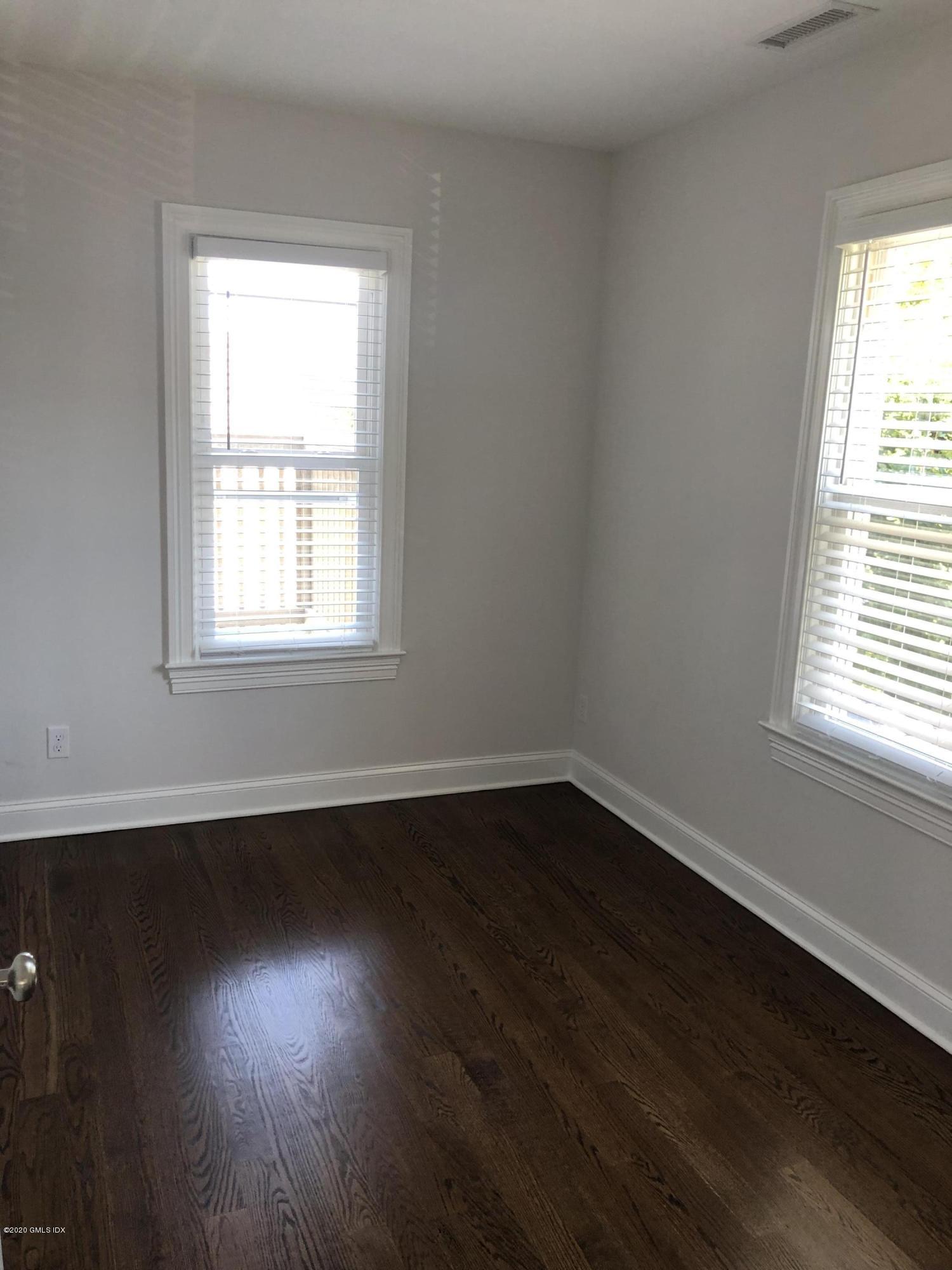30 Harold Avenue, Unit 2 Greenwich, CT 06830 - Photo 9 of 11 an empty room with wooden floor and windows