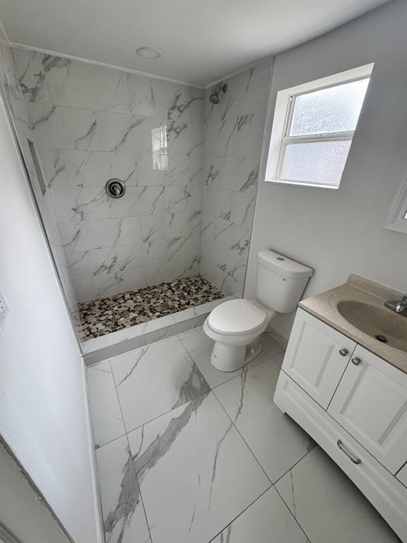 412 Fleming Avenue Greenacres, FL 33463 - Photo 2 of 3 a bathroom with a granite countertop sink a toilet and a shower