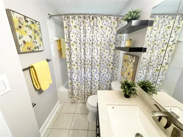 a bathroom with a sink a toilet and shower curtain
