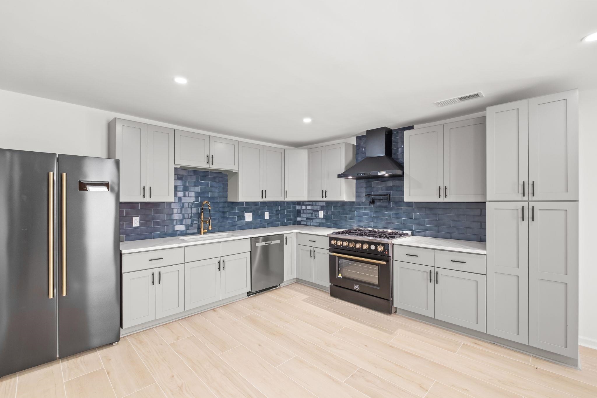6224 Benjestown Road Memphis, TN 38127 - Photo 12 of 39 Kitchen with stainless steel appliances, recessed lighting, wood finish floors, backsplash, and light stone countertops