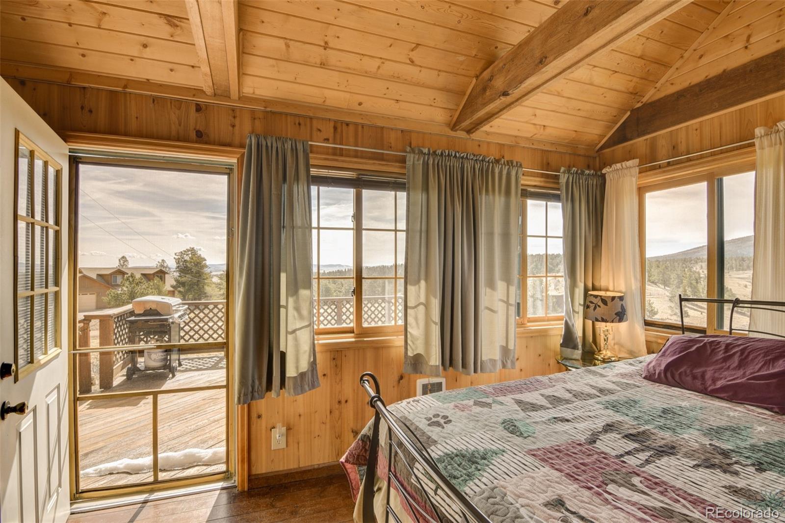 3750 Singletree Road Hartsel, CO 80449 - Photo 31 of 46 a bedroom with a bed and glass door