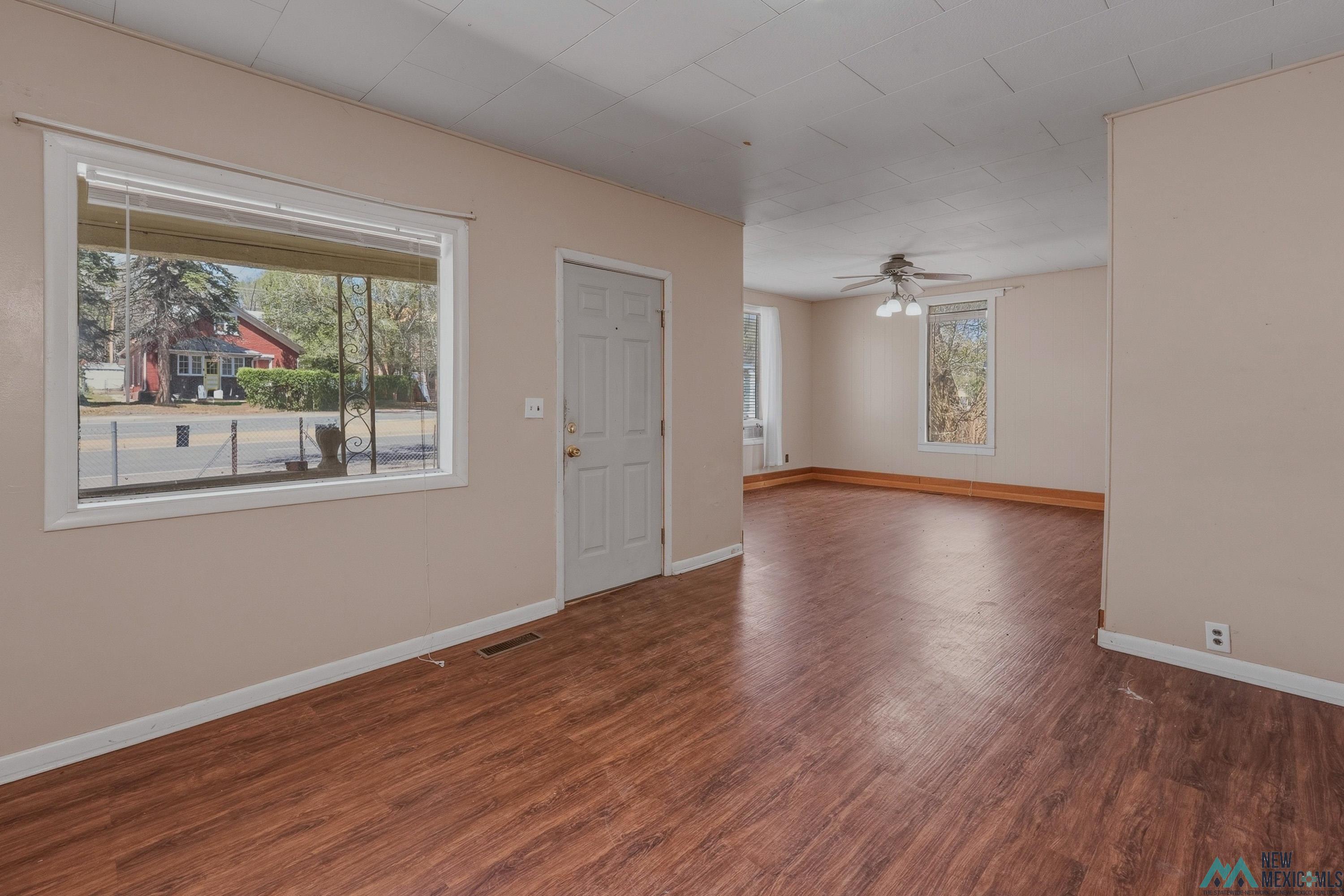533 South 2nd Street Raton, NM 87740 - Photo 6 of 43 Spacious interior featuring wood-finish flooring, neutral wall tones, and white trim throughout