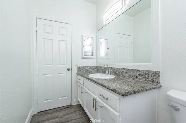 a bathroom with a granite countertop sink and a mirror