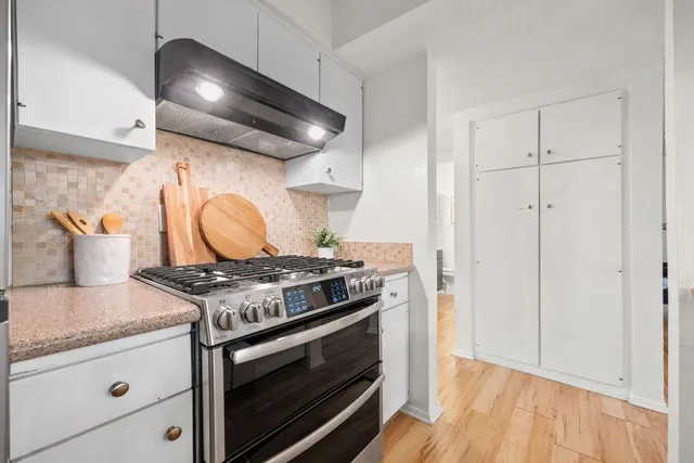 a stove top oven sitting inside of a kitchen