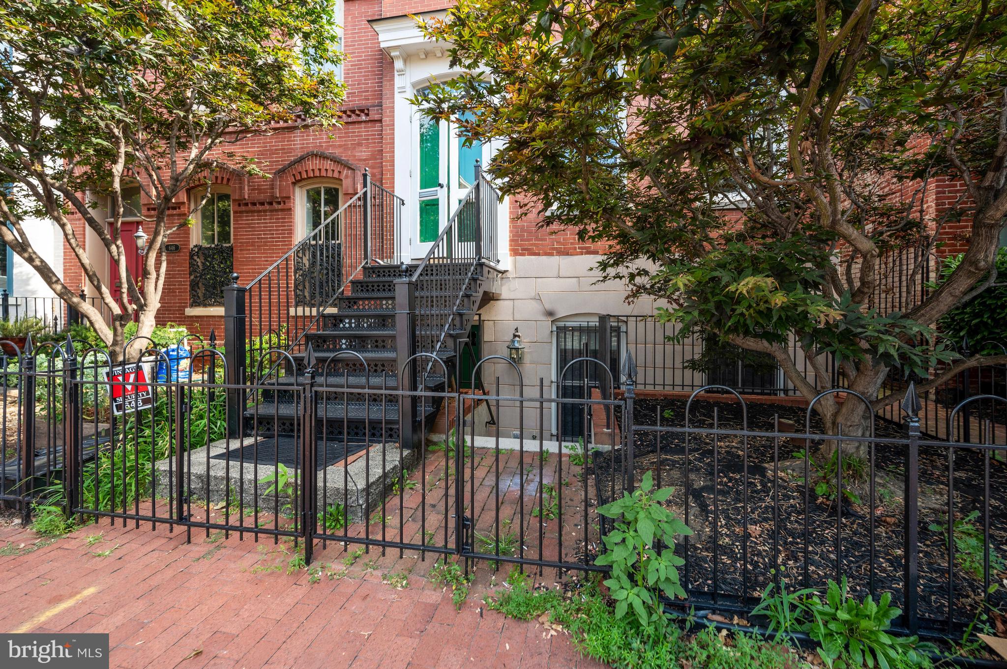 648 C Street Northeast, Unit 1 Washington, DC 20002 - Photo 2 of 17 a view of house with wooden fence and large trees