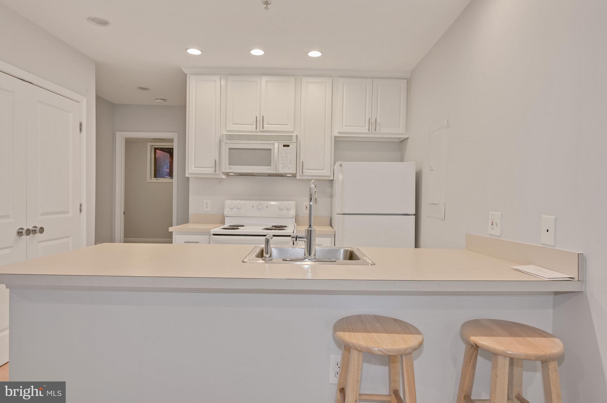 648 C Street Northeast, Unit 1 Washington, DC 20002 - Photo 8 of 17 a kitchen with stainless steel appliances granite countertop a sink a stove a refrigerator and white cabinets with wooden floor