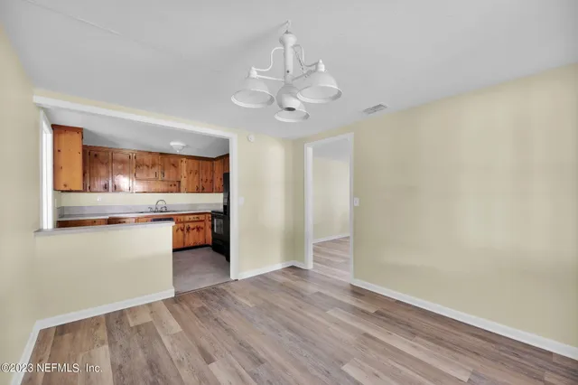 wooden floor in an empty room with a kitchen