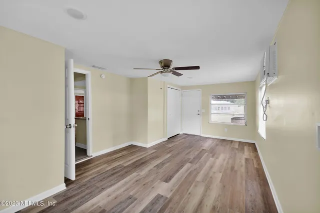 a view of empty room with wooden floor