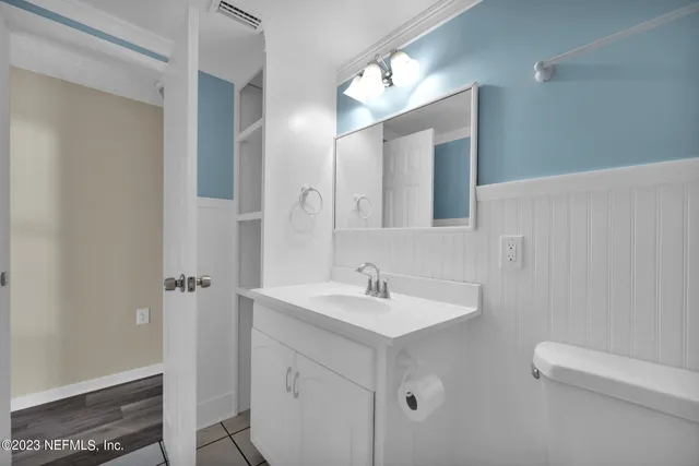 a bathroom with a double vanity sink a mirror and a toilet