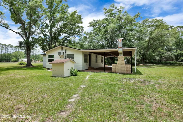 a view of a house with backyard porch and sitting area