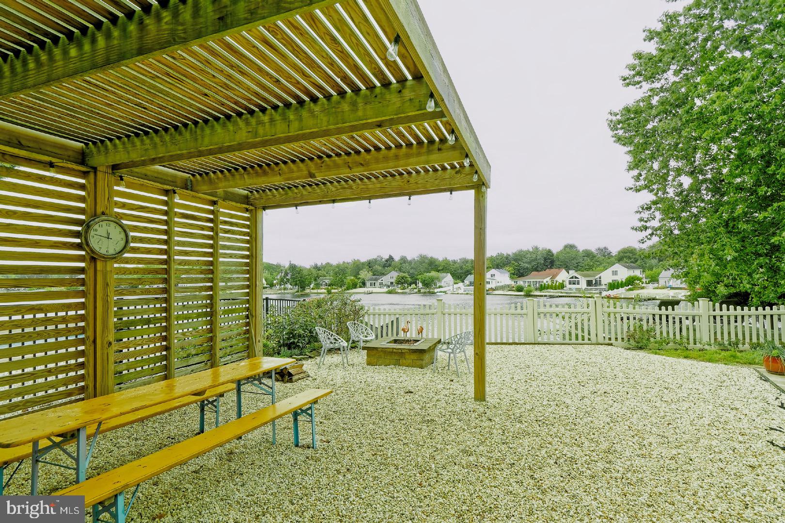 84 Jennings Road Manahawkin, NJ 08050 - Photo 33 of 40 a view of a lake with a bench and wooden floor
