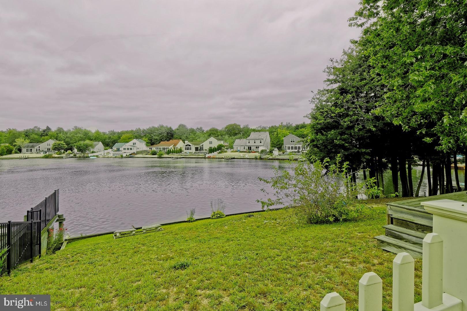 84 Jennings Road Manahawkin, NJ 08050 - Photo 37 of 40 a backyard of a house with lots of green space and lake view