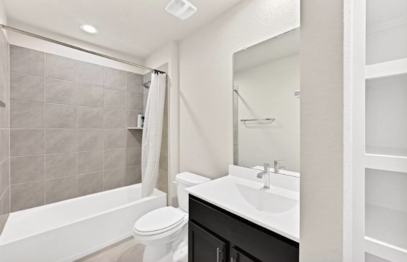 7311 Ramsgate Cliff Lane Richmond, TX 77407 - Photo 14 of 21 a bathroom with a sink a toilet and a large mirror
