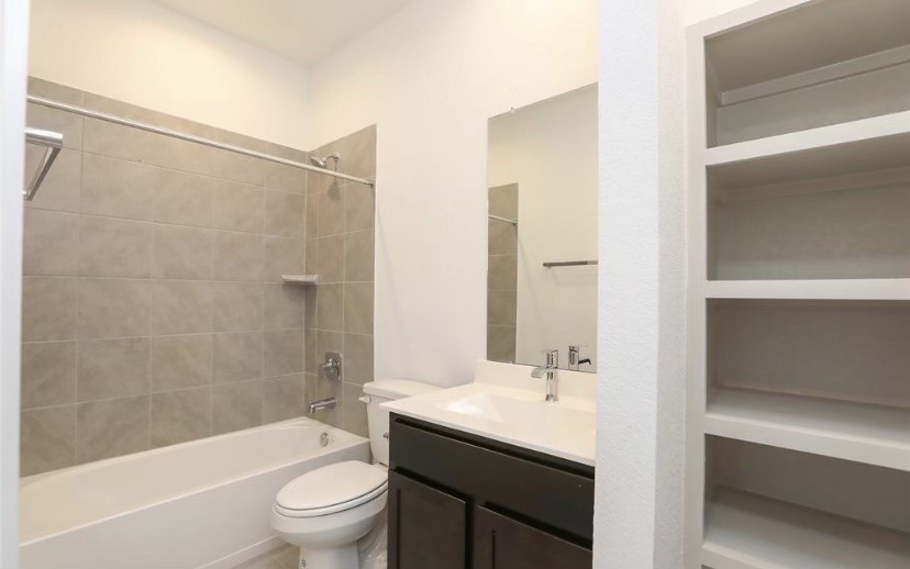 7311 Ramsgate Cliff Lane Richmond, TX 77407 - Photo 15 of 21 a bathroom with a granite countertop sink a toilet and shower