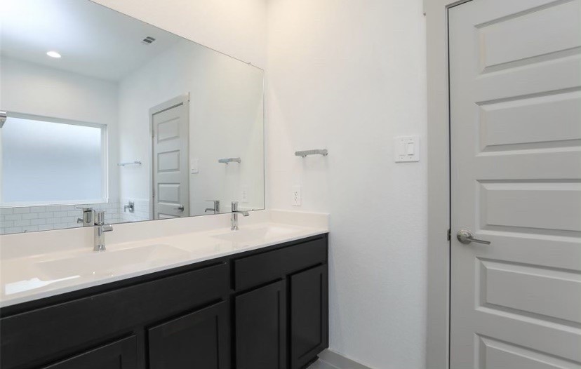7311 Ramsgate Cliff Lane Richmond, TX 77407 - Photo 16 of 21 a bathroom with a double vanity sink and mirror