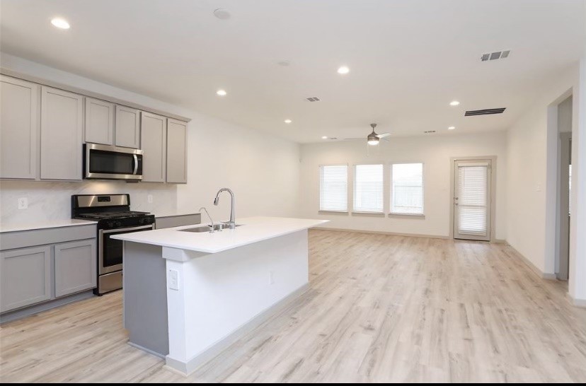 7311 Ramsgate Cliff Lane Richmond, TX 77407 - Photo 2 of 21 a large kitchen with stainless steel appliances granite countertop a sink and cabinets