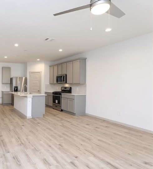 7311 Ramsgate Cliff Lane Richmond, TX 77407 - Photo 5 of 21 a large kitchen with a large counter top a sink stainless steel appliances and cabinets