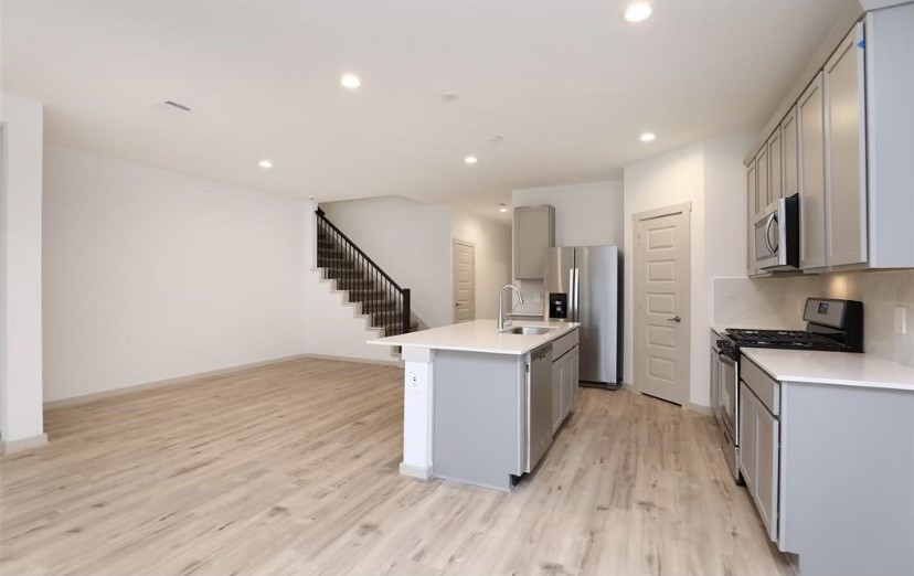 7311 Ramsgate Cliff Lane Richmond, TX 77407 - Photo 6 of 21 a kitchen with a sink cabinets stainless steel appliances and wooden floor