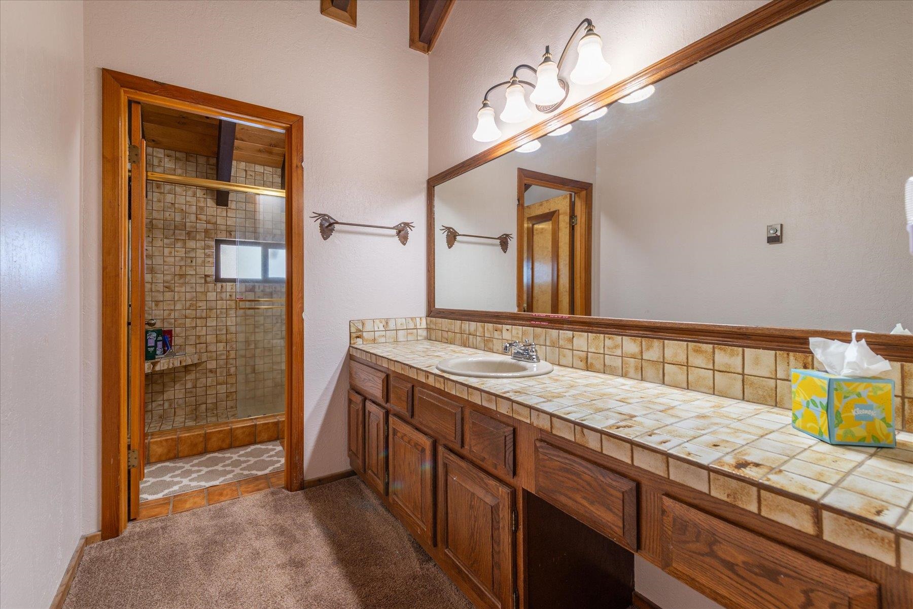 17080 Ski Slope Way Truckee, CA 96161 - Photo 12 of 22 a bathroom with a granite countertop sink and a mirror
