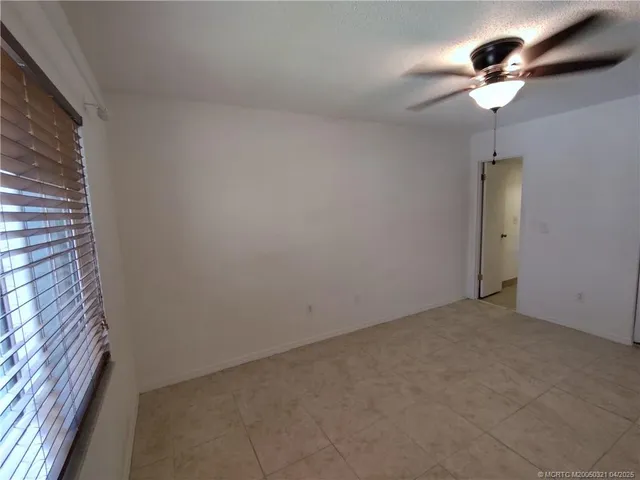 a view of an empty room with a chandelier fan