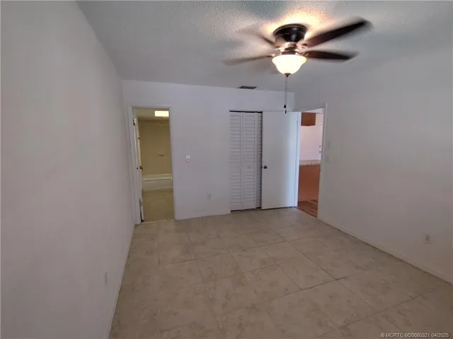 en empty room with ceiling fan and window