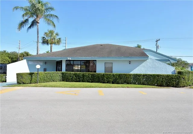 a front view of house with yard and trees around