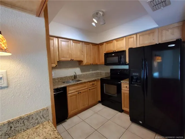 a kitchen with stainless steel appliances granite countertop a refrigerator and a stove