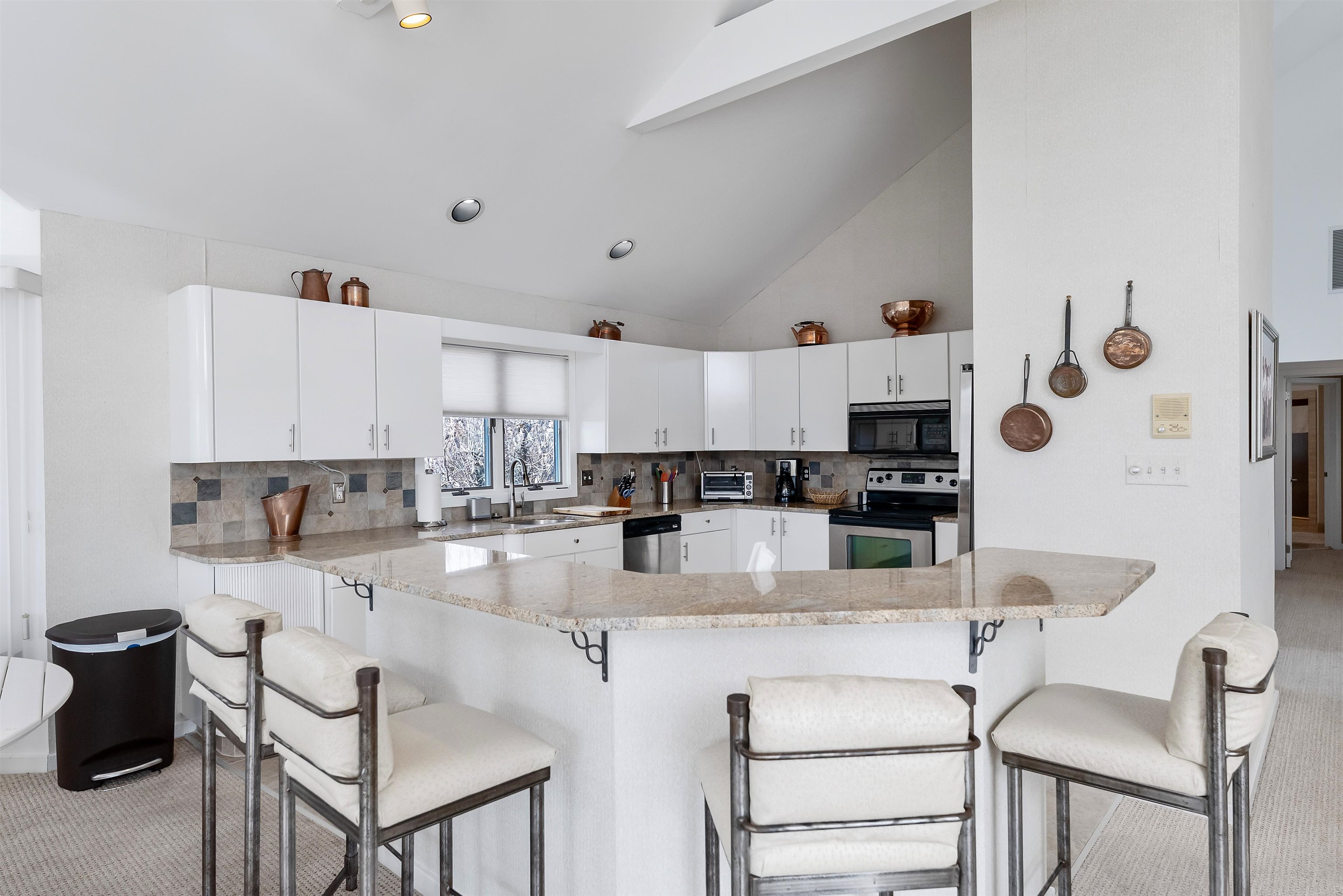 177 71st Street Avalon, NJ 08202 - Photo 15 of 44 a kitchen with stainless steel appliances granite countertop a stove top oven a sink a dining table and chairs with white cabinets