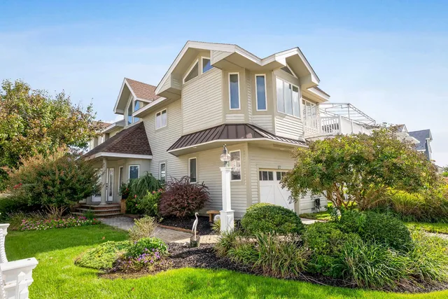 a front view of a house with a yard and potted plants