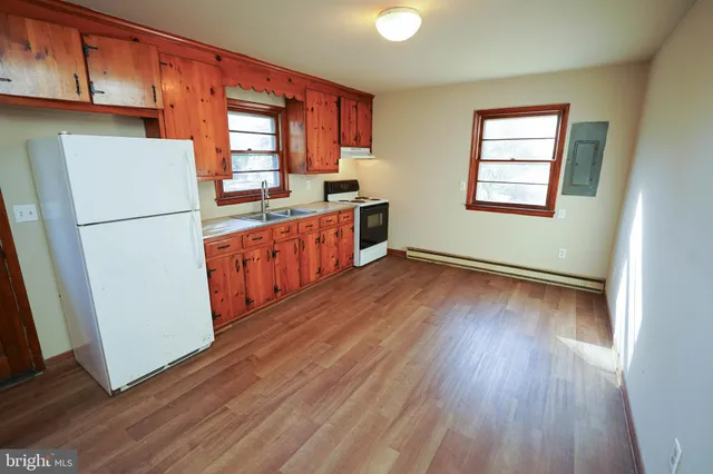 a kitchen with wooden floors and white appliances