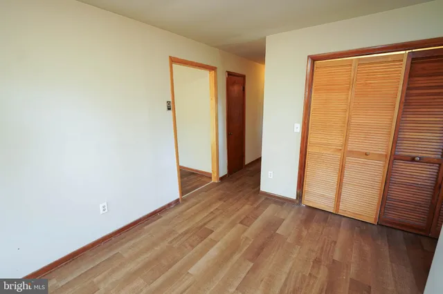 an empty room with wooden floor and a window