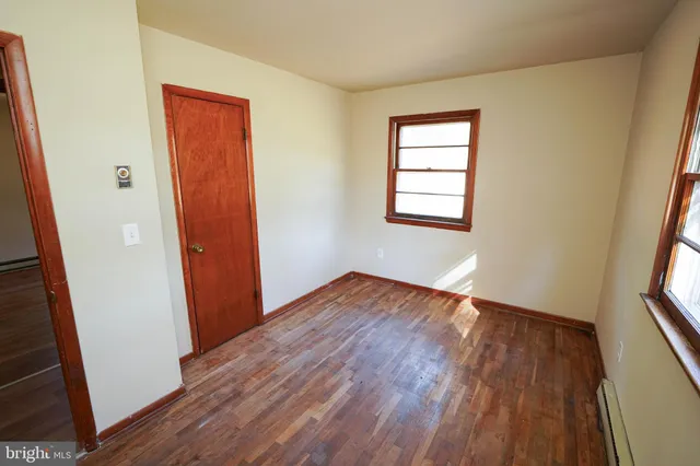 an empty room with wooden floor and a window