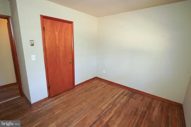 an empty room with wooden floor and door