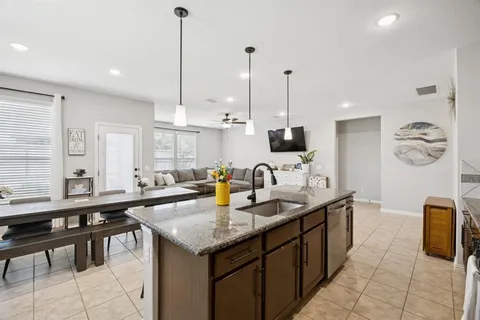a kitchen with stainless steel appliances granite countertop a sink counter space and living room view