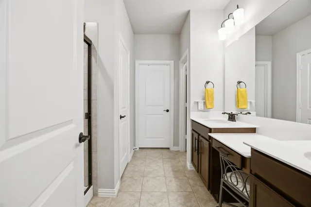 a spacious bathroom with a double vanity sink a mirror and a bathtub