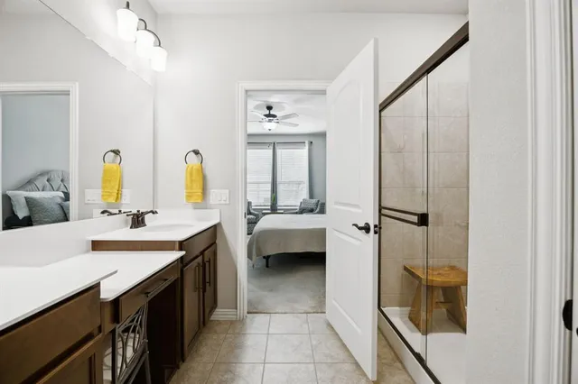 a bathroom with a double vanity sink a mirror and a bathtub