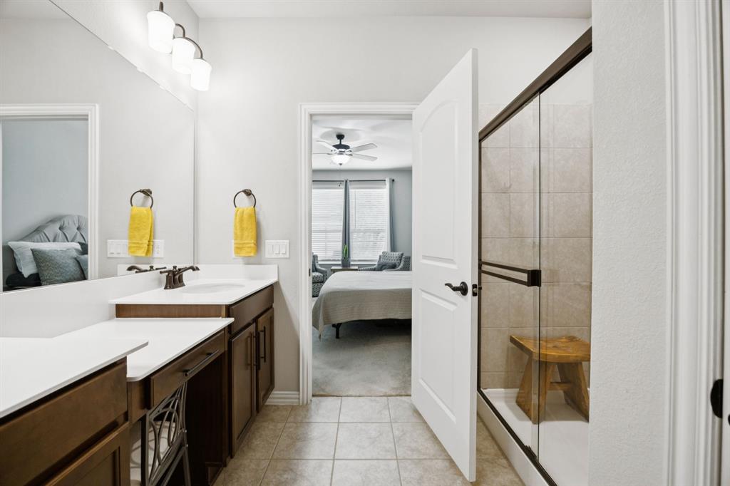 2448 Jack Rabbit Way Northlake, TX 76247 - Photo 6 of 40 a bathroom with a double vanity sink a mirror and a bathtub