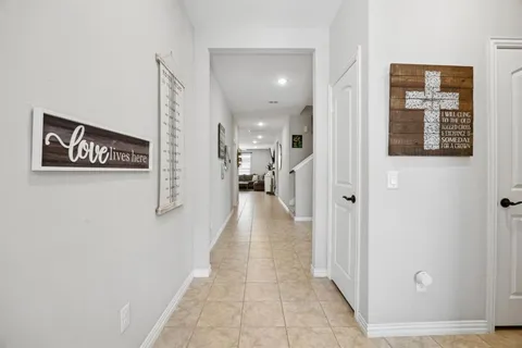 a view of a hallway with wooden floor and a living room