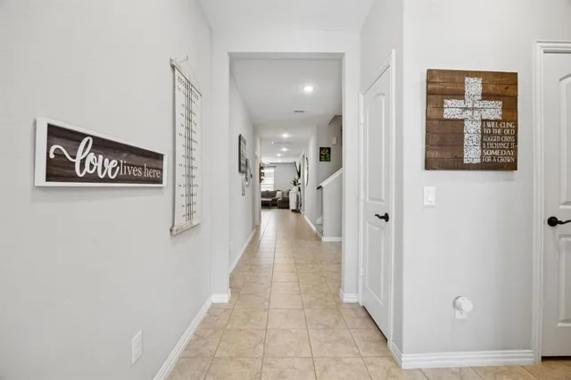a view of a hallway with wooden floor and a living room