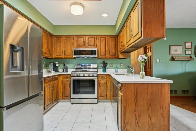 a kitchen with stainless steel appliances granite countertop a stove a sink and a refrigerator