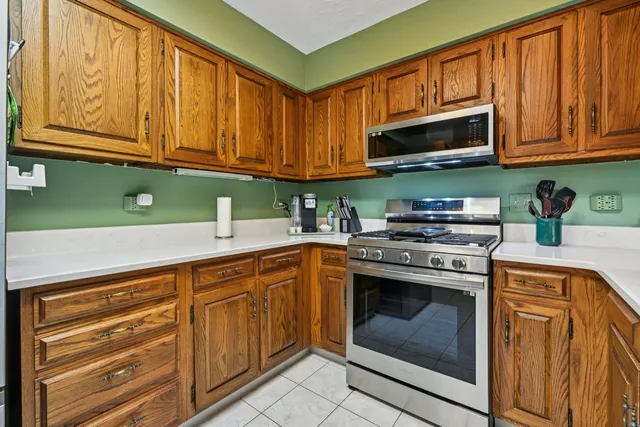 a kitchen with stainless steel appliances granite countertop a stove top oven microwave and cabinets