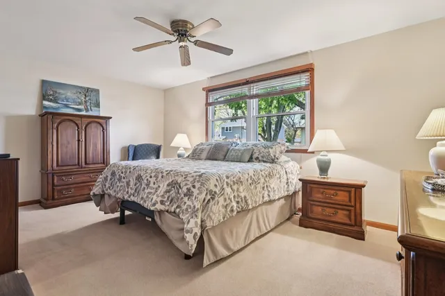 a bedroom with a bed a window and dresser