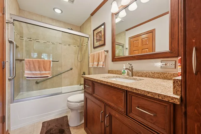 a bathroom with a granite countertop sink toilet and shower