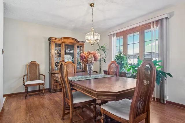 a dining room with furniture a chandelier and wooden floor