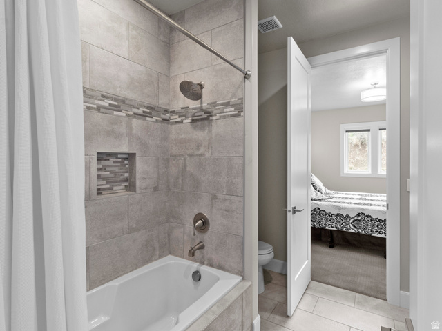 614 East High Lane Alpine, UT 84004 - Photo 62 of 75 Full bathroom featuring tiled shower / bath combo, connected bathroom, light tile patterned floors, and light carpet
